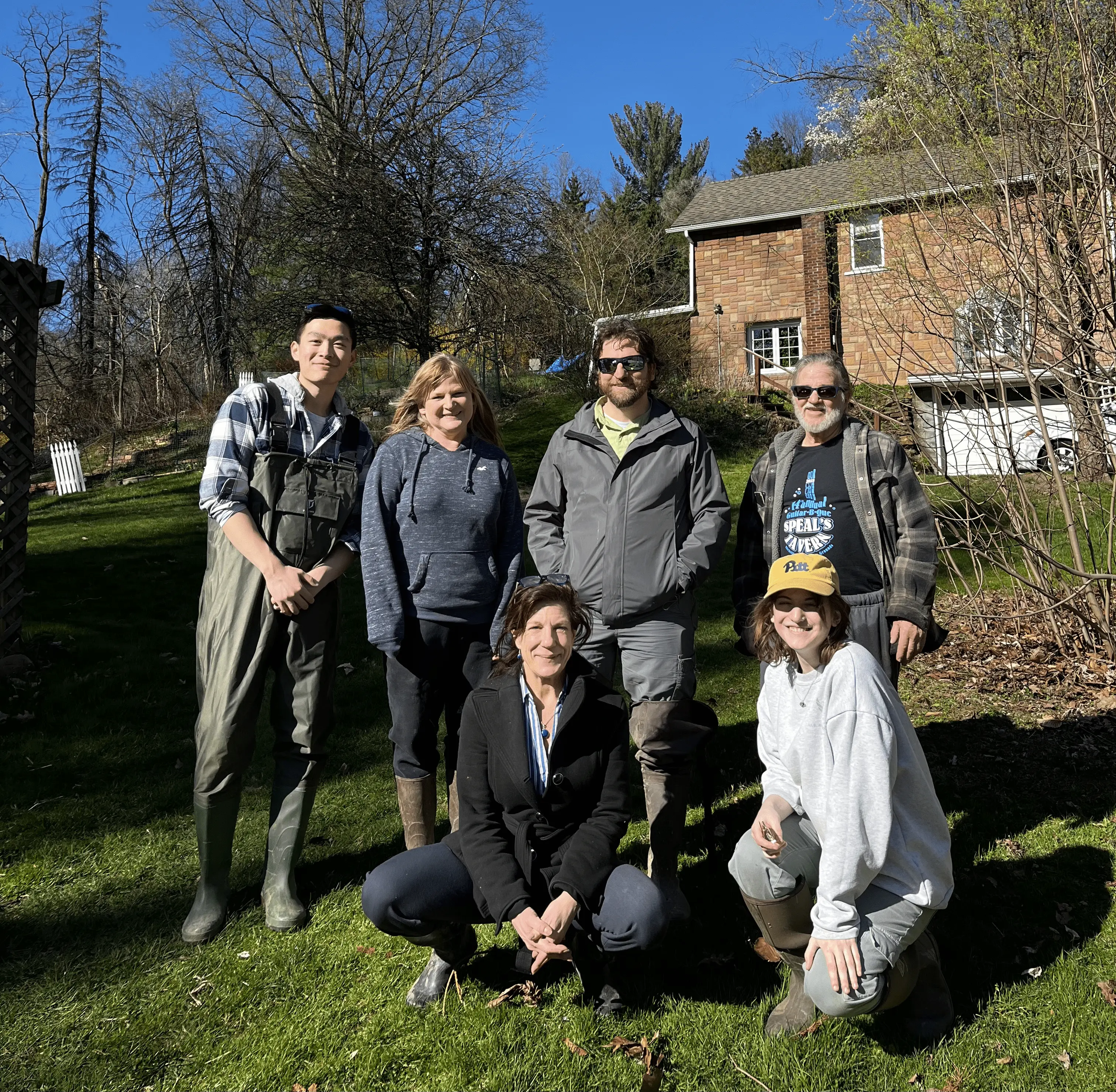 A group photo of members standing in the afternoon sun